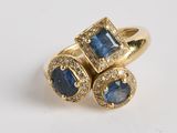 gros plan d'une bague en or avec saphirs bleus et diamants