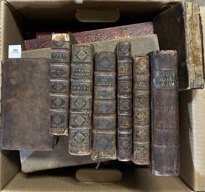 Plusieurs vieux livres se trouvent dans une boîte en carton posée sur une table