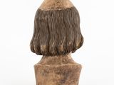 a close up of a wooden bust of a man with long hair