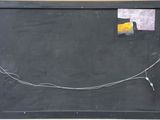 a blackboard with a piece of paper on it and wires attached to it