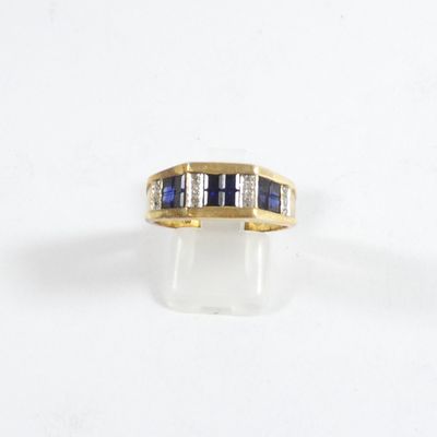 un gros plan d'une bague en or jaune sertie de saphirs et de diamants