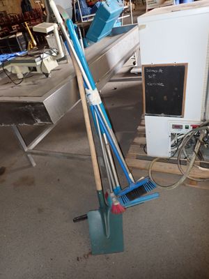 a blue broom and a blue broom on the floor next to a white refrigerator