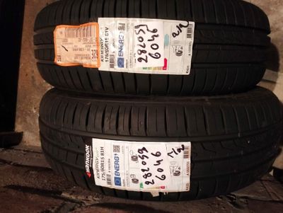 two tires are stacked on top of each other on a brick floor