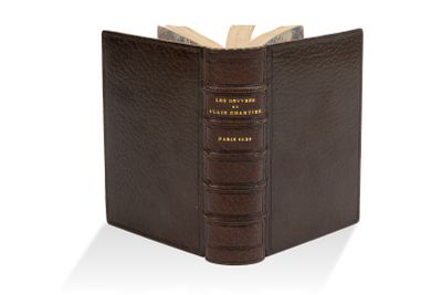 un vieux livre à la couverture marron, orné d'une inscription dorée
