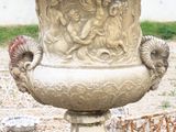 un grand vase en pierre posé sur un socle en pierre