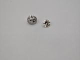 une paire de boucles d'oreilles en diamant posée sur une surface blanche