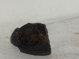 a rock that is sitting on the ground next to a white wall
