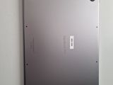 the back of a silver laptop with a metal cover on a white wall