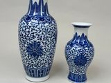 two blue and white vases sitting next to each other on a table