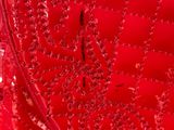 the back of a red dress with sequins and beads on it