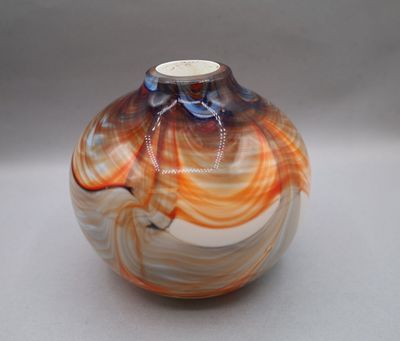a picture of a glass vase with orange and white swirls