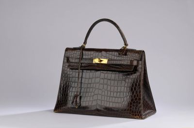 a brown crocodile skin handbag with gold hardware