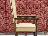 a chair that is sitting in front of a wall with red and white wallpaper