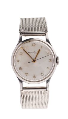 a close up of a wrist watch with a mesh band