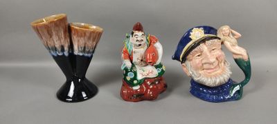 trois figurines en céramique posées les unes à côté des autres sur une table