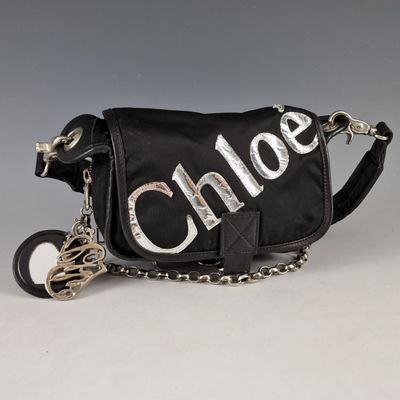 black shoulder bag with silver letters and a chain