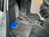 the interior of a car with the door open and the driver ' s seat down