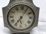 a silver clock with roman numerals on the face