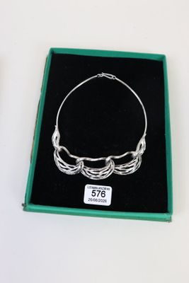 un bracelet en argent qui a été placé dans une boîte verte