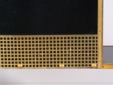a mirror with a gold frame on a white shelf