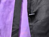 a man wearing a purple shirt and black tie
