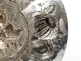 a silver vase that has a design on it