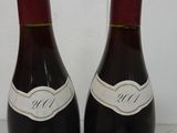 two bottles of wine sitting on top of a table next to each other