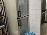 des bouteilles d'eau sont posées devant un réfrigérateur ouvert dans une cuisine