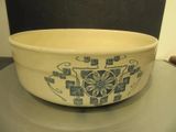 a white bowl with blue designs on it sitting on a table