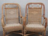 pair of wicker chairs against a wall with a white wall in the background