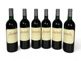 six bouteilles de vin sont alignées sur une surface blanche
