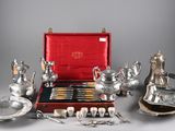 an assortment of silverware including teapots, cups, and spoons