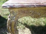 une table en bois ornée de sculptures, posée dans l'herbe