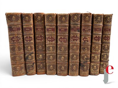 several old books are lined up in a row on a white surface