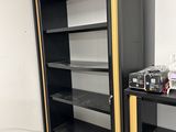 a black and gold bookcase in the corner of a room