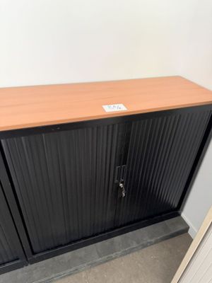 une armoire noire avec un plateau en bois dans une pièce