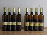 six bouteilles de vin sont alignées sur une table en bois