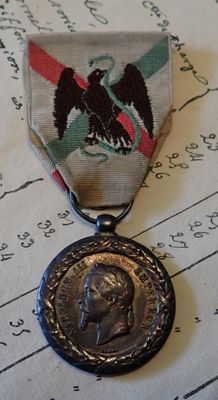 une médaille sur laquelle figure le portrait d'un homme, posée sur une partition