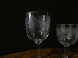 two wine glasses sitting on a table with a black background