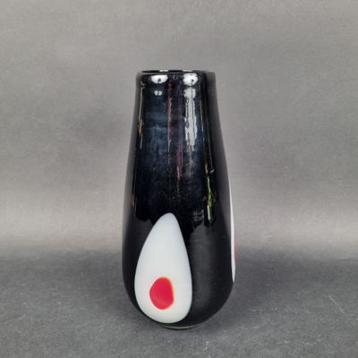 un vase noir orné d'un motif blanc et rouge