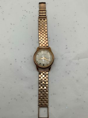 an image of a gold wrist watch on a white surface
