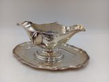 un service en argent ancien composé d'une assiette et d'une soucoupe posée dessus