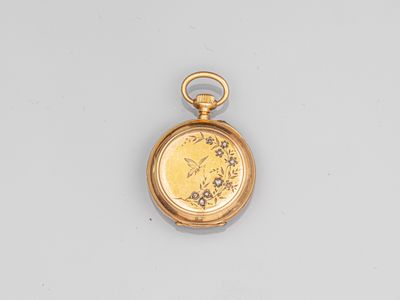 a close up of a gold pocket watch on a white surface