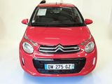 a red car that is parked in a white room