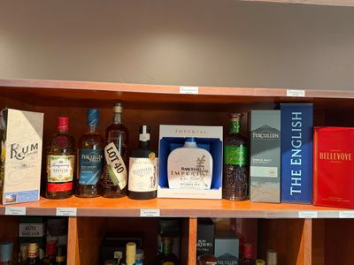 de nombreuses bouteilles d'alcool et des livres sur une étagère