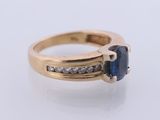 a close up of a ring with a sapphire and diamonds