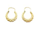 une paire de boucles d'oreilles créoles en or sur fond blanc