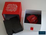 a red heart shaped object in a box on a table