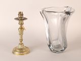 un vase en verre et un bougeoir en laiton posés sur une table