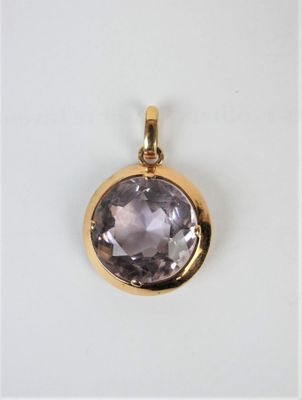 a close up of a gold plated pendant with a faceted amethorate